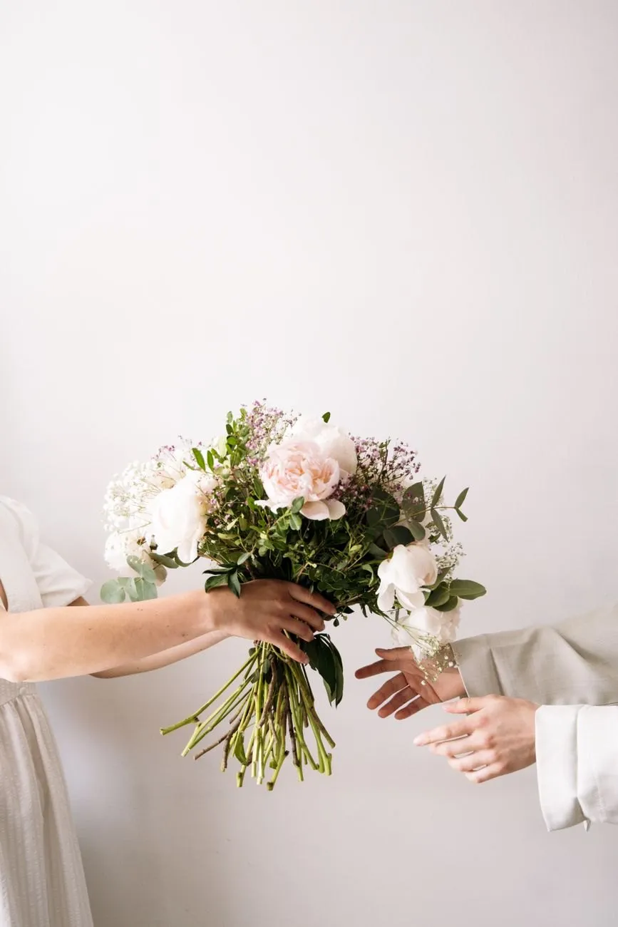 A bouquet handed from one pair of hands to another